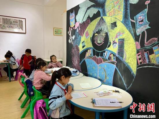 图为当地儿童在三宝儿童图书馆开馆当日看书学习。 张冬冬 摄