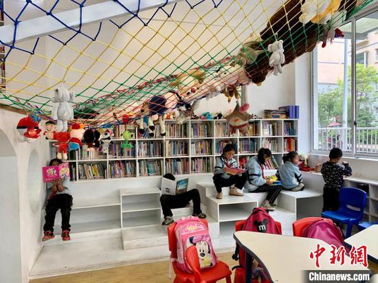 图为当地儿童在三宝儿童图书馆开馆当日看书学习。 张冬冬 摄