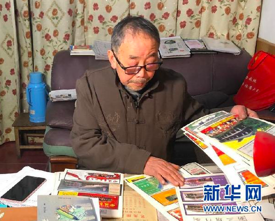 杨敏志在整理自己收藏的遵义会议会址门票(2021年1月11日摄)。新华社记者 李惊亚 摄