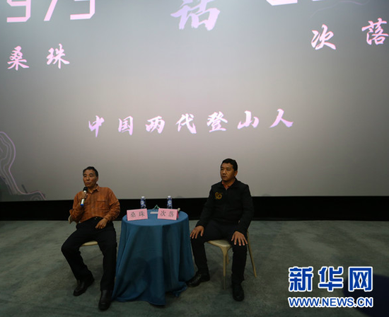 4月24日,两位时隔45年完成珠峰测量任务的登山勇士桑珠(左)、次落(右)在贵阳介绍珠峰登山测量情况,与观众互动交流。新华网 黄勇 摄
