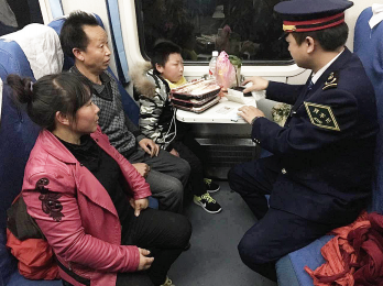 列车长刘犇正在了解陈某一家情况(图由K111次列车提供)