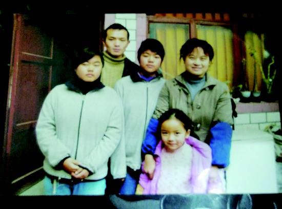 卓欣、卓欢上初二时,李泽英一家五口在租住房前,拍下了这张“全家福”