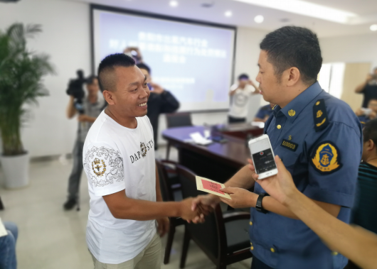 贵阳市道路运输管理局副局长何骏给龙政金颁发奖金