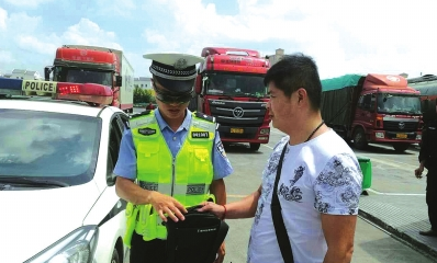 游客将捡到的手提包交给交警。