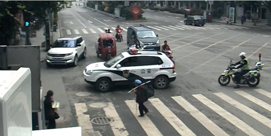 警车缓缓护送老人过斑马线(视频截图)