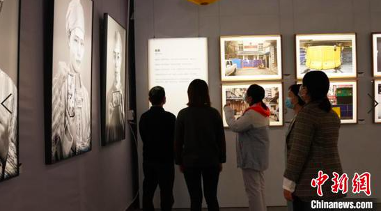 游客在镇远古城观看摄影展。徐伟 摄