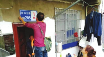 安装人员更换新楼牌。