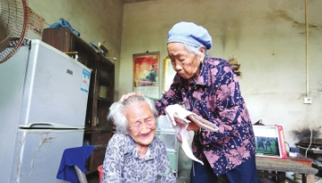 唐老久(右)给高东秀洗脸。 胡攀学 摄