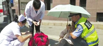女子接受救治时,交警一直用肩膀给她当依靠,并为她撑伞遮阳。