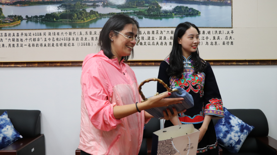 旅游领事维吉尼亚·雅普女士接受布依绣娘手工制作的包