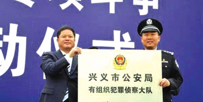 黔西南州委书记刘文新(左一)向兴义市公安局授牌。