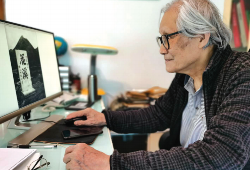 彭匡查看由胶卷转换而来的花溪公园老照片。