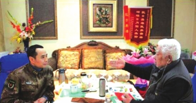 杨健部长认真听赵爷爷讲述革命经历。
