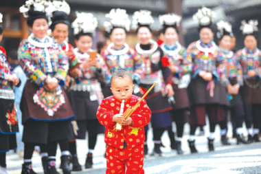 一名小孩子在“祭尤节”中吹奏芦笙。