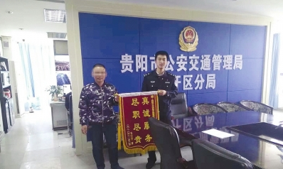 张某给查获自己的交警送锦旗表感谢。