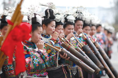 身着节日盛装的苗族妇女在“祭尤节”中吹奏苗族传统乐器“芒筒”。