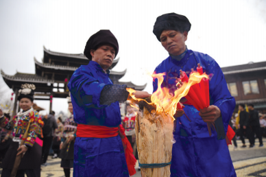 苗族祭师在“祭尤节”中用祭火点燃香烛。