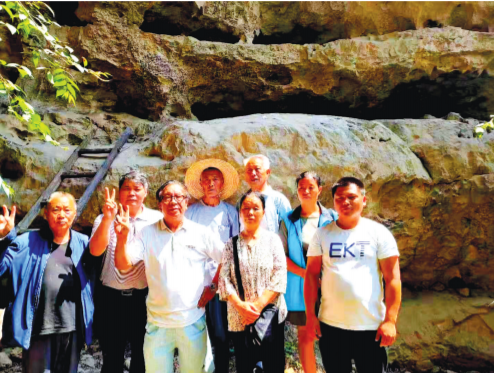 王教授和当地干部群众在“天书”前合影。
