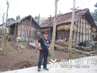2014年，龚绍祖在贵州织金县官寨联盟村与茅草房合影。