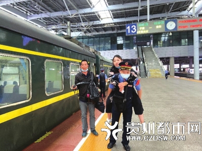 列车值班员姜嘉彬背着女子上车。