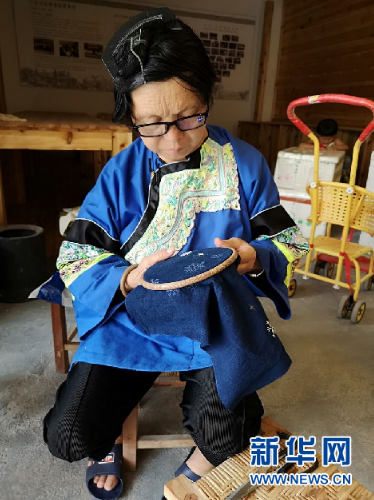 杨老团正在卧龙小区的扶贫车间做刺绣。新华社记者罗羽摄