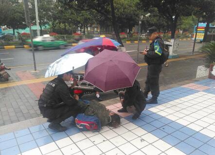 民警为伤者撑伞挡雨。