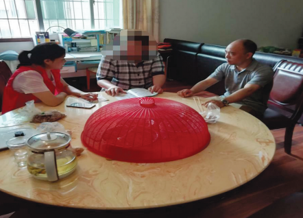 社区工作人员和莫某谈心。