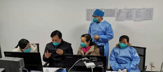 王万灵(左二)与医护人员讨论疫情医疗救治方案