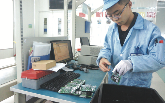 贵阳永青仪电科技有限公司员工将初步检测过的芯片板放入塑料盒
