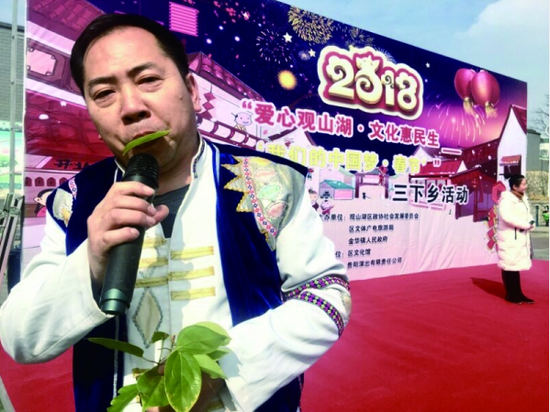 万金贵用一片樟树叶吹奏乐曲。