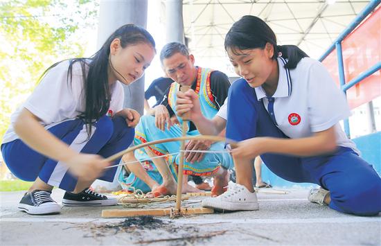 5月29日，保亭黎族苗族自治县保亭中学学生在学习钻木取火技艺。