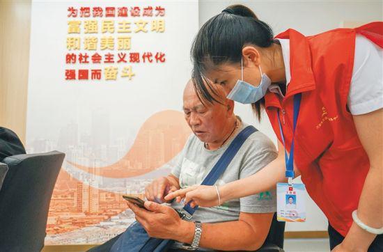 近日,在三亚市天涯区党群服务中心开设的老年人手机课堂上,志愿者在教老人用智能手机。本报记者 武威 摄