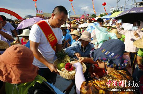 农民代表为现场群众分享丰收果实 记者王晓斌摄
