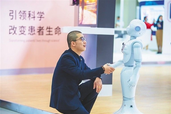 在博鳌乐城国际医疗旅游先行区国际创新药械转换中心，医生在和机器人互动。 阮琛 摄