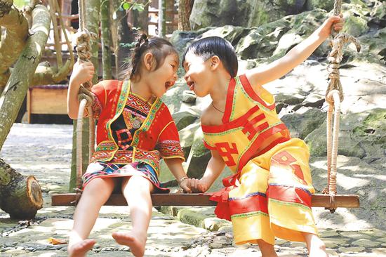 槟榔谷景区，小游客穿上黎家传统服饰荡秋千。海南日报记者 武威 摄