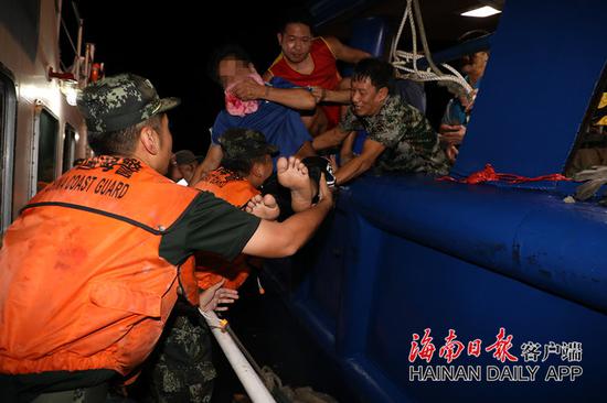 ↑救援官兵将患病渔民转移至海警舰艇上。