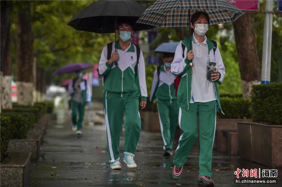 图为海南华侨中学的高三学生戴口罩步入校园.骆云飞摄