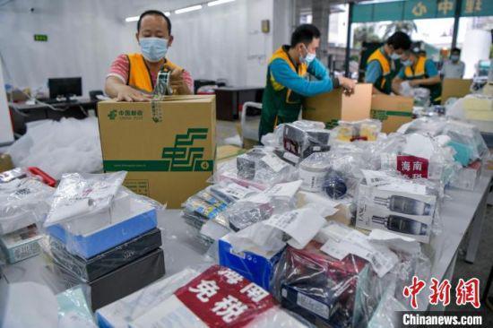 中国邮政集团公司海口市分公司工作人员正在打包“邮寄送达”快件。 骆云飞 摄