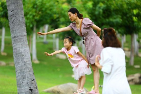 7月24日，家长带着孩子在三亚南山文化旅游区游览、拍照 陈文武摄