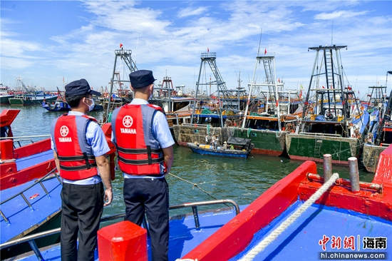  图为海南临高县公安局新盈海岸派出所民警在渔港执勤。骆云飞摄