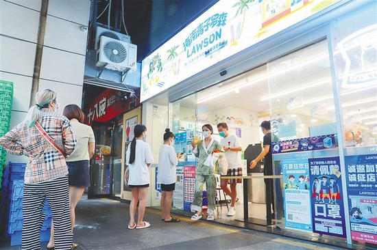 9月14日,三亚市吉阳区大东海社区,居民有序排队购买生活物资。 王程龙 摄