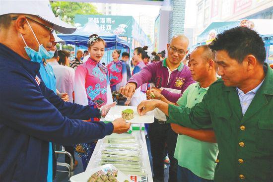 市民游客争先品尝儋州馆的辣木香糕。 方山 摄