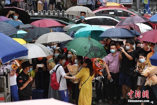  6月9日，广东省广州市第十六中学考点外，家长等待考生结束最后一科考试。 中新社记者 陈楚红 摄