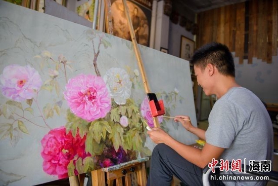 图为海南省屯昌县油画步行街的画师作画。凌楠 摄