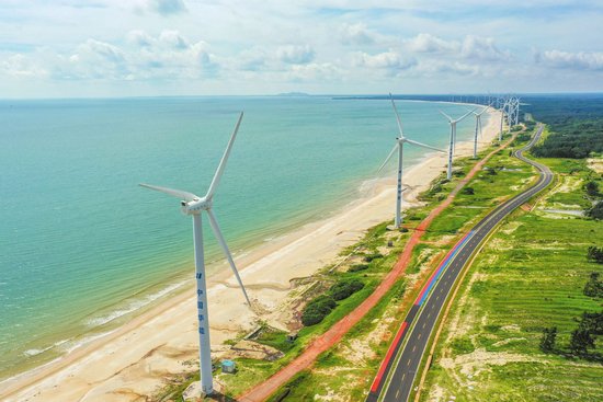 6月25日，俯瞰海南环岛旅游公路文昌风车海岸段，绵延数公里的风车群和公路相伴而行。孙士杰 摄