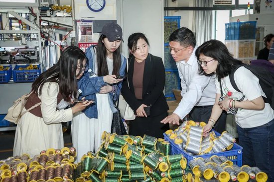 媒体记者在义乌庆春科技有限公司生产车间采访当地分支机构工作人员
