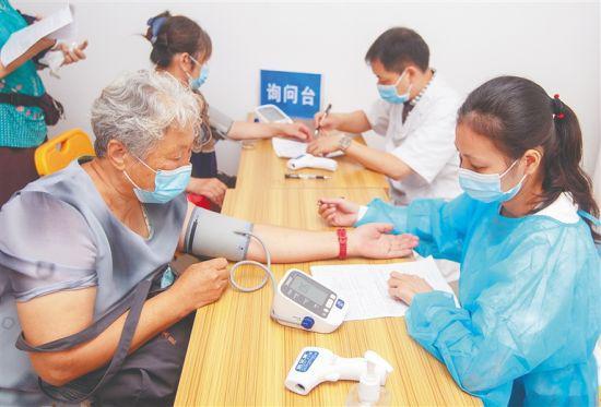 近日，海口市人民医院，医护人员在给准备接种新冠疫苗的市民做检查。本报记者 袁琛 摄
