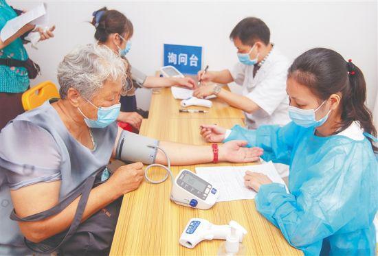 近日，海口市人民医院，医护人员在给准备接种新冠疫苗的市民做检查。本报记者 袁琛 摄