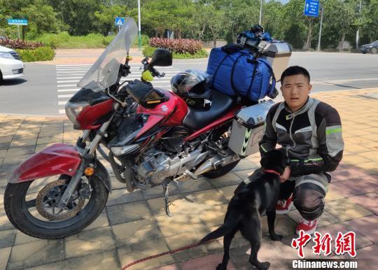 周浩与自己的小狗“小二”、摩托车“小红”。 林士杰 摄