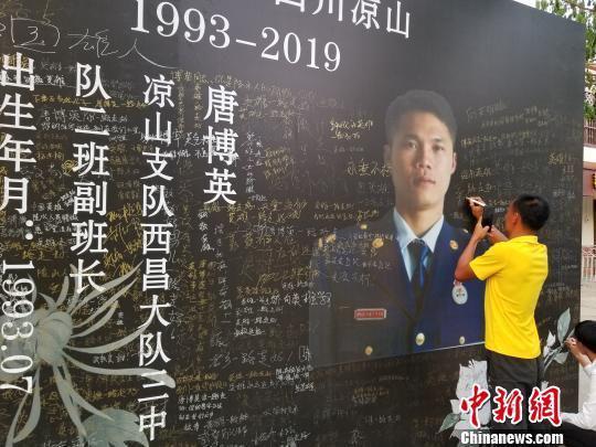 一位村民在纪念墙上签字悼念。　王晓斌　摄